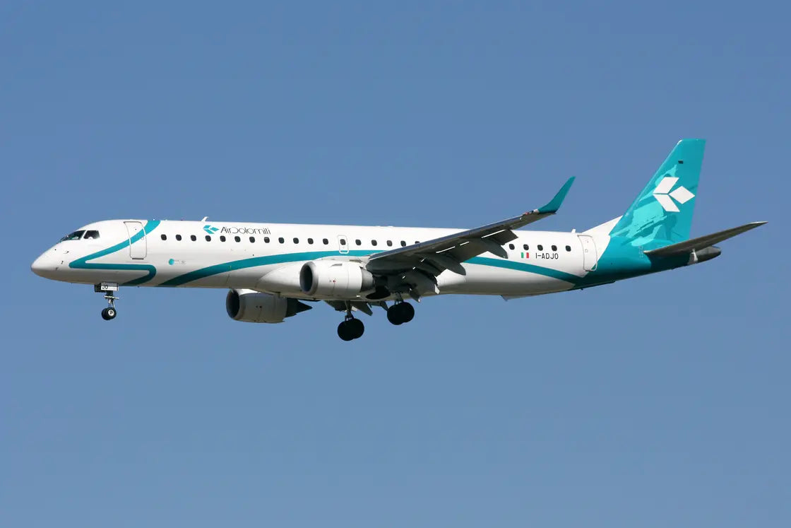 Air Dolomiti Embraer 195LR aircraft in flight, seen from the side against a clear blue sky.