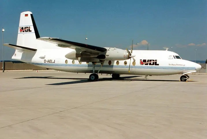 Side view of a Fokker F-27-600 Friendship aircraft operated by WDL Aviation, parked on a tarmac under a clear blue sky.