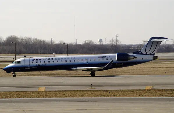 A GoJet CRJ-700 aircraft with United Express livery taxiing on an airport runway.