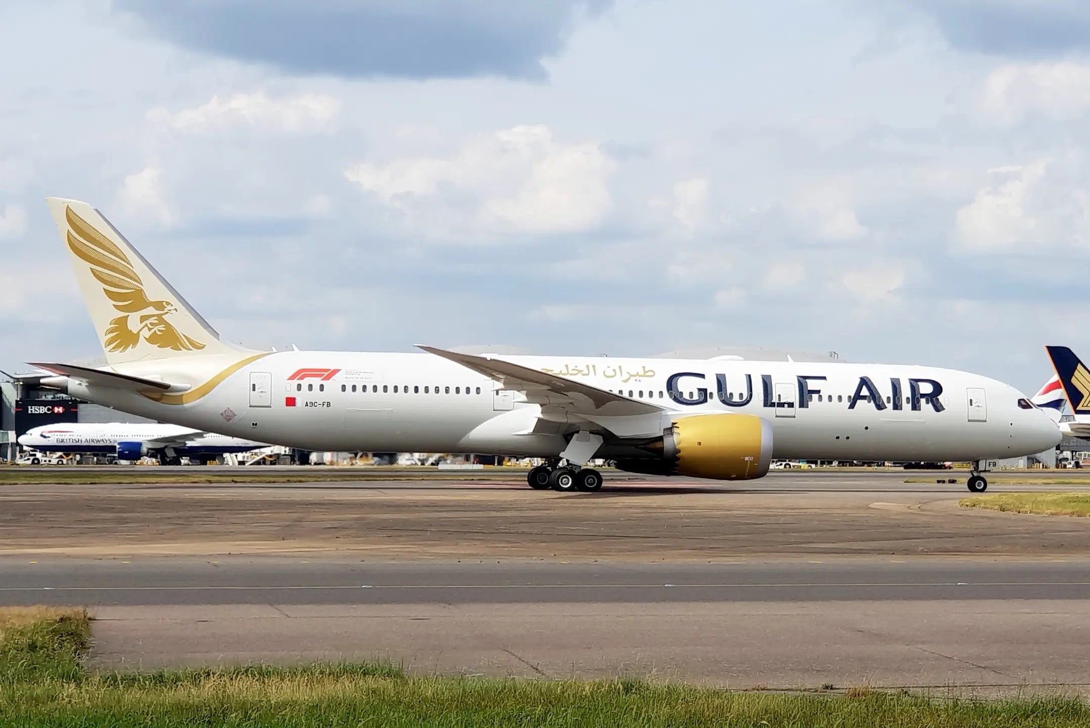 A Gulf Air Boeing 787 Dreamliner on a runway with a clear sky in the background.