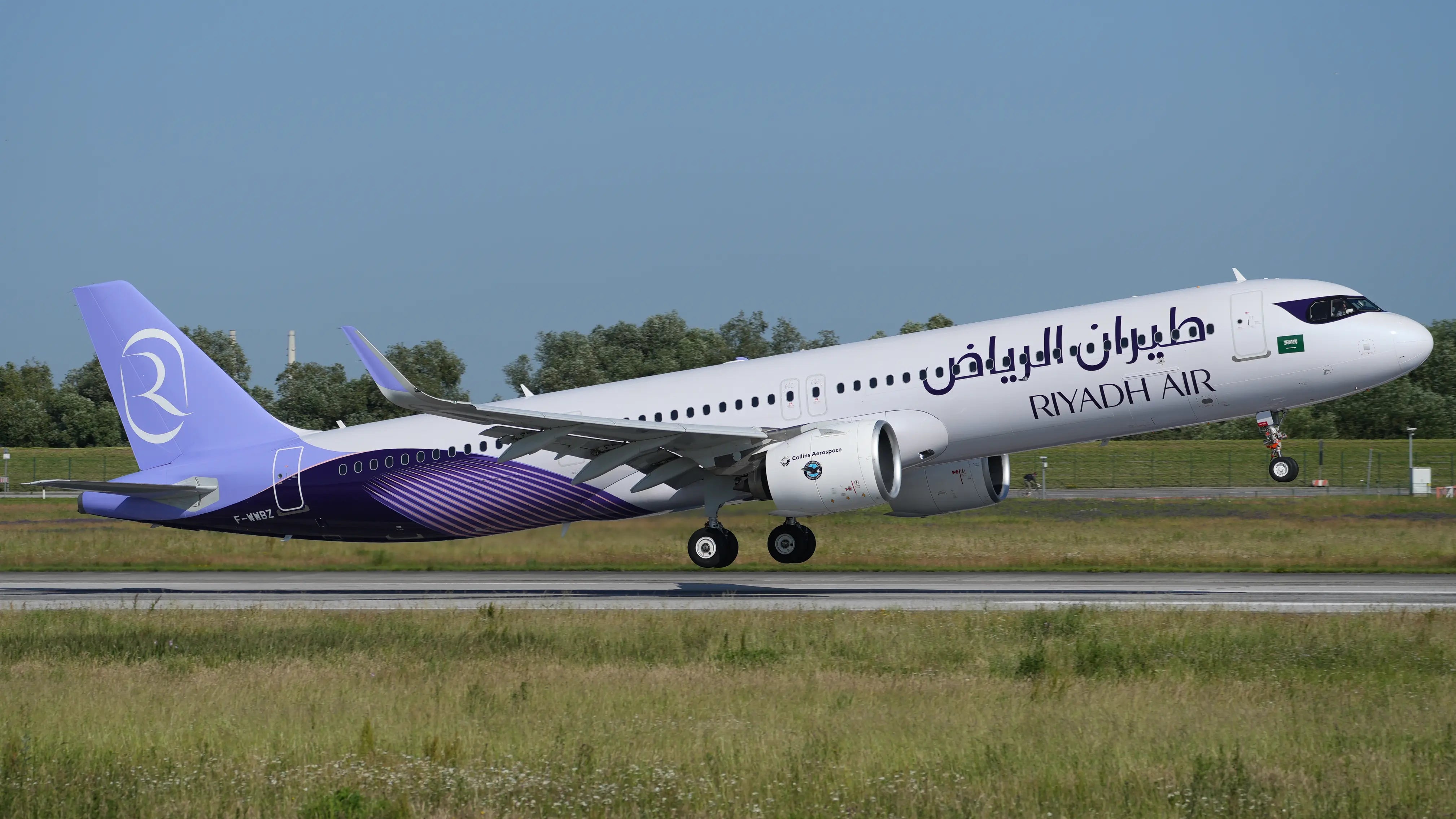 Riyadh Air Airbus A321-271NY XLR aircraft with purple tail and white body taking off at Hamburg-Finkenwerder Airport.