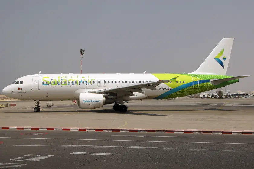 SalamAir Airbus A320 aircraft with registration A4O-OVC parked at Muscat Airport, showcasing its green and white livery on a sunny day.