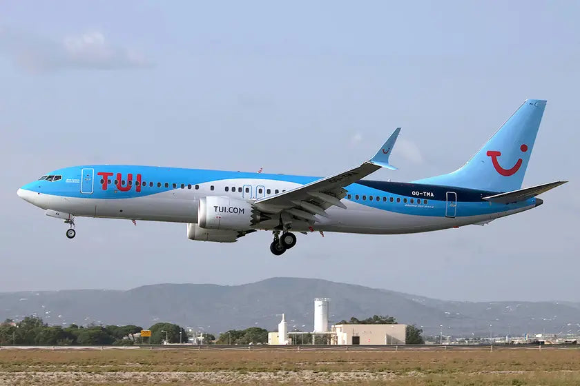 Boeing 737-8 MAX aircraft of TUI Airlines Belgium, registration OO-TMA, in flight with landing gear down against a clear sky background.
