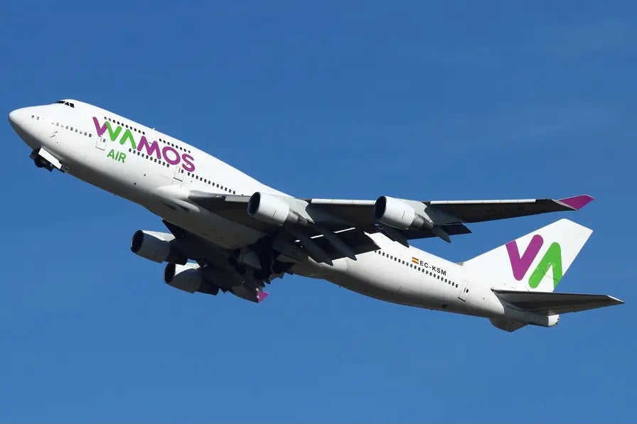 Wamos Air Boeing 747-400 aircraft in flight, viewed from below, taking off against a clear blue sky at Paris-Orly Airport.