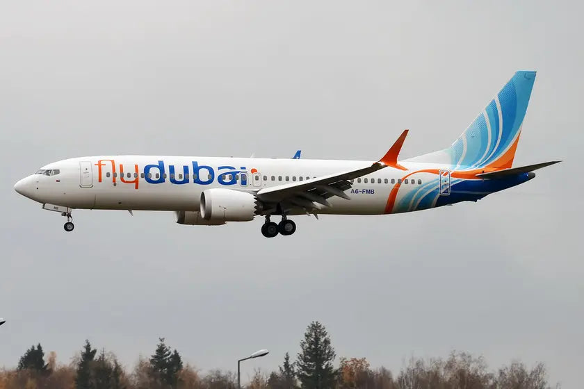 FlyDubai Boeing 737-8 MAX aircraft, registration A6-FMB, in flight with flydubai logo and colorful tail design, against a cloudy sky backdrop.