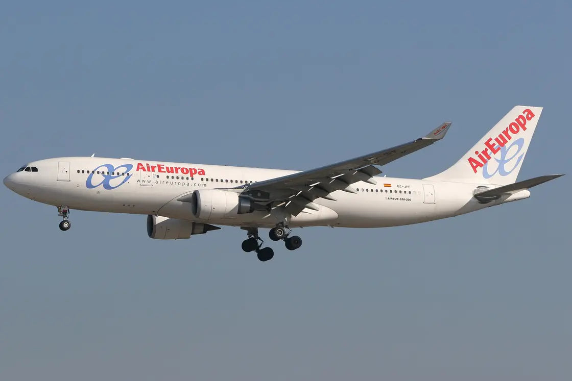 Air Europa Airbus A330-202 aircraft in flight, displaying landing gear and livery, against a clear blue sky.