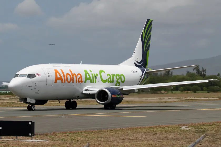 Aloha Air Cargo Boeing 737-330(SF) taxiing on the runway at Honolulu Airport on a cloudy day, featuring distinctive livery.