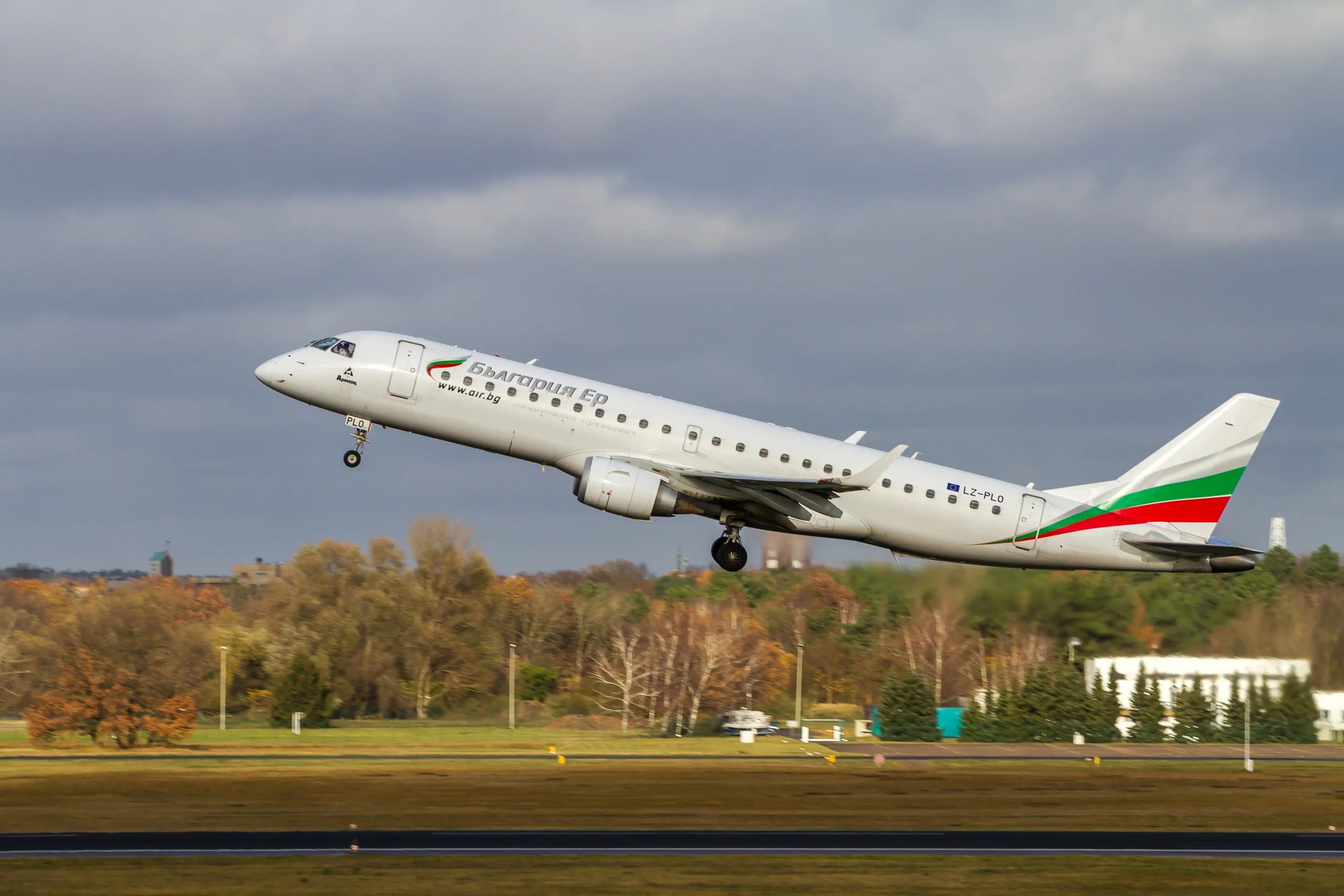 A Bulgaria Air aircraft, LZ-PLO, taking off from Tegel Airport, Berlin, against a backdrop of trees and overcast sky.