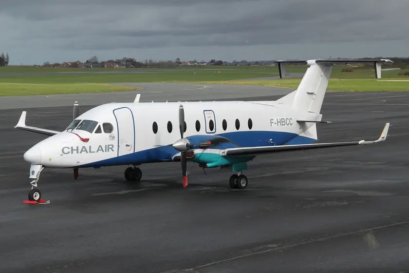 A Beech 1900D airliner operated by Chalair on a tarmac at Le Havre Octeville Airport, France, under a cloudy sky.