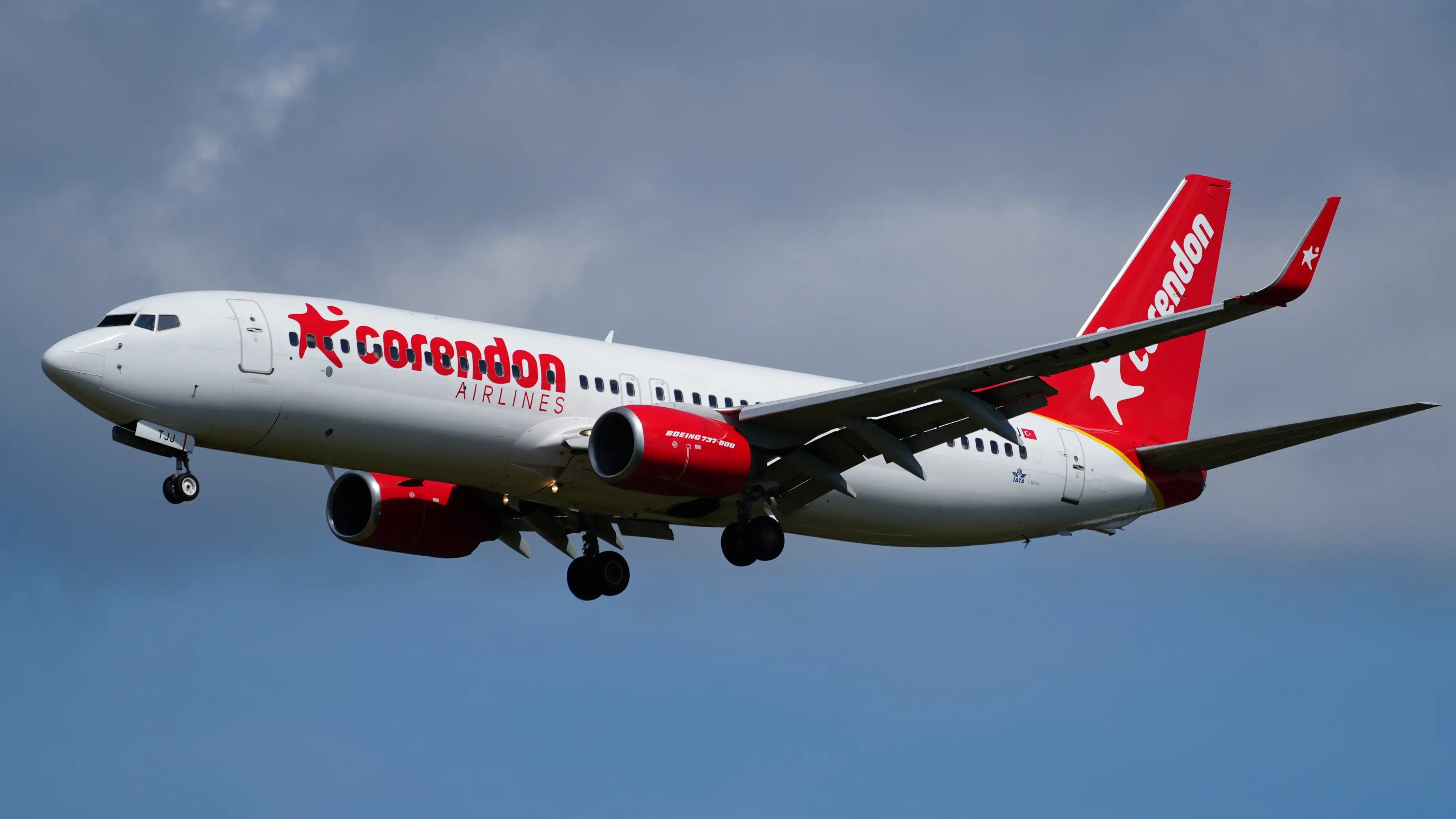 Corendon Airlines Boeing 737-8S3 with winglets in flight against a cloudy sky at Hamburg Airport.