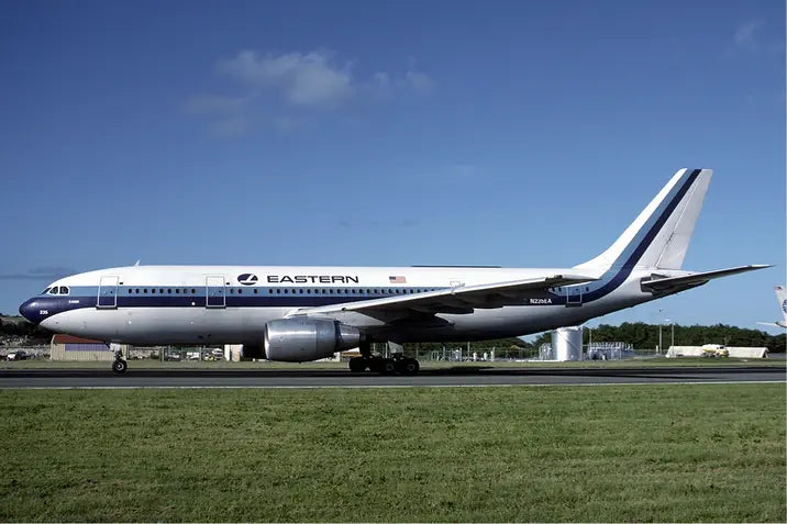 Eastern Air Lines Airbus A300 taxiing at St Maarten Airport in December 1986, with blue sky and surrounding airport facilities in the background.