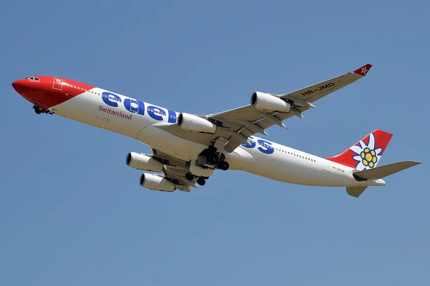 Edelweiss Air Airbus A340-313 with registration HB-JMD in flight, showcasing its distinctive red and blue livery and edelweiss flower on the tail.