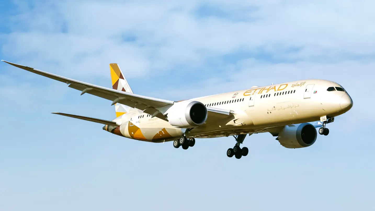 Etihad Airways Boeing 787-9 Dreamliner A6-BLL in flight against a blue sky.
