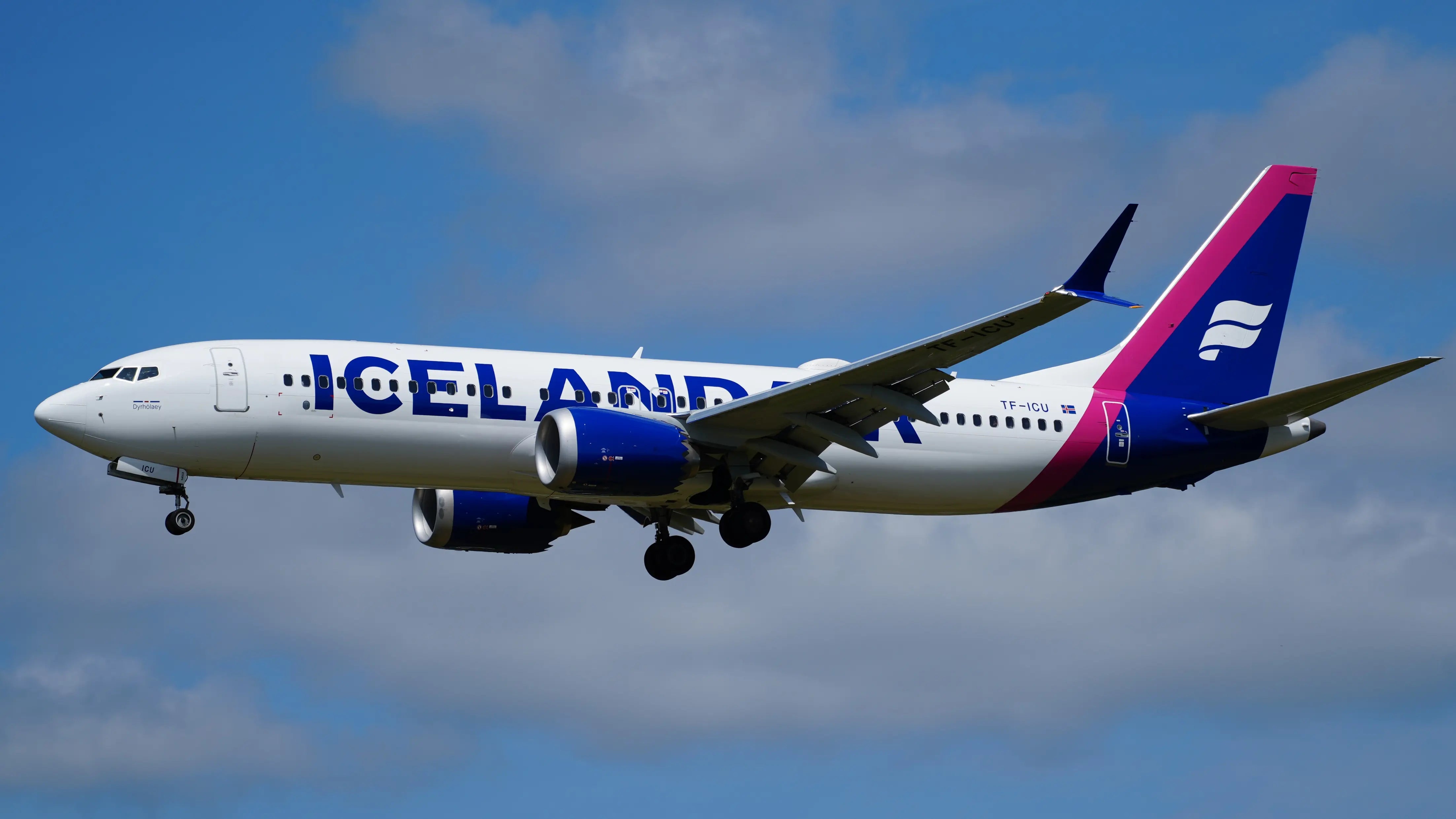 Icelandair Boeing 737-8 MAX TF-ICU aircraft in flight at Hamburg Airport, blue sky background.