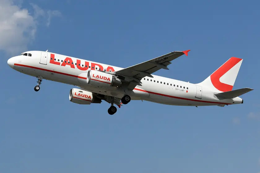 Lauda Europe Airbus A320-214 airplane in flight with 9H-LMP registration, featuring distinctive red and white livery against blue sky background.