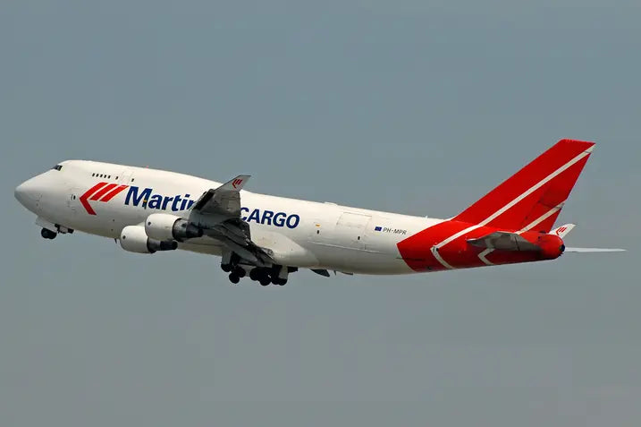 Martinair Cargo Boeing 747-400F aircraft in flight with red and white livery against a clear sky, viewed from the side.