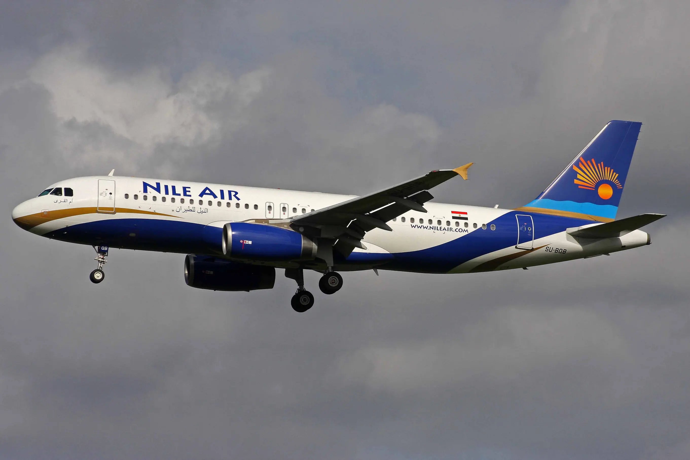 Nile Air Airbus A320-232 aircraft in flight against a cloudy sky, displaying the airline's logo and branding.