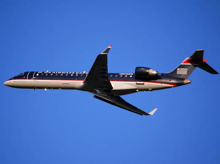 A US Airways Express jet in flight against a clear blue sky.