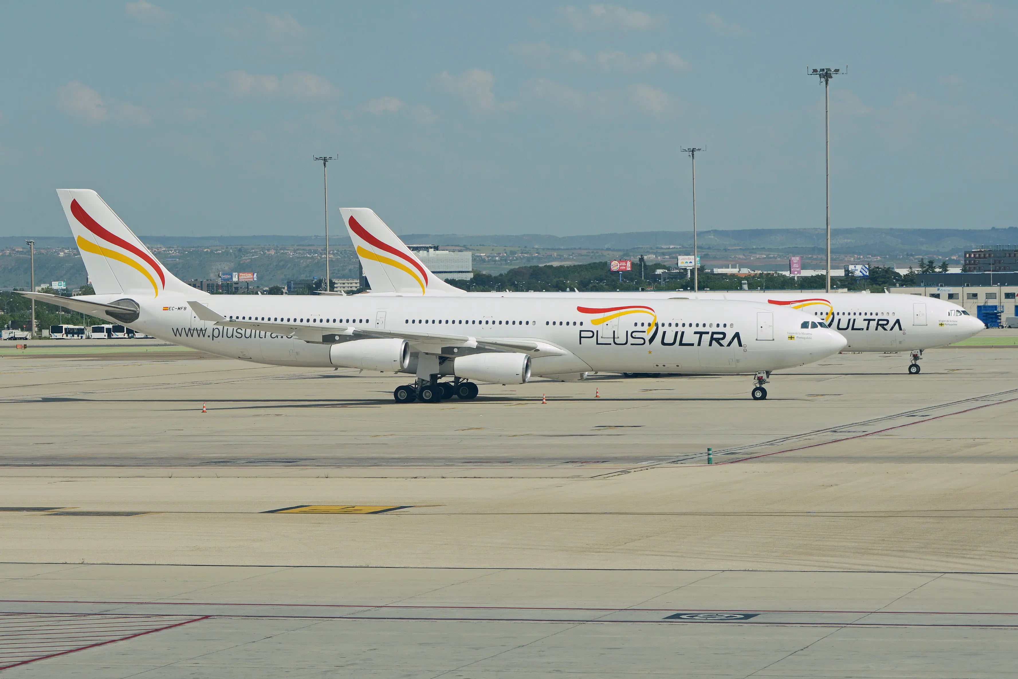Two Plus Ultra LÍneas Aéreas Airbus A340 planes parked on an airport tarmac under a clear sky.