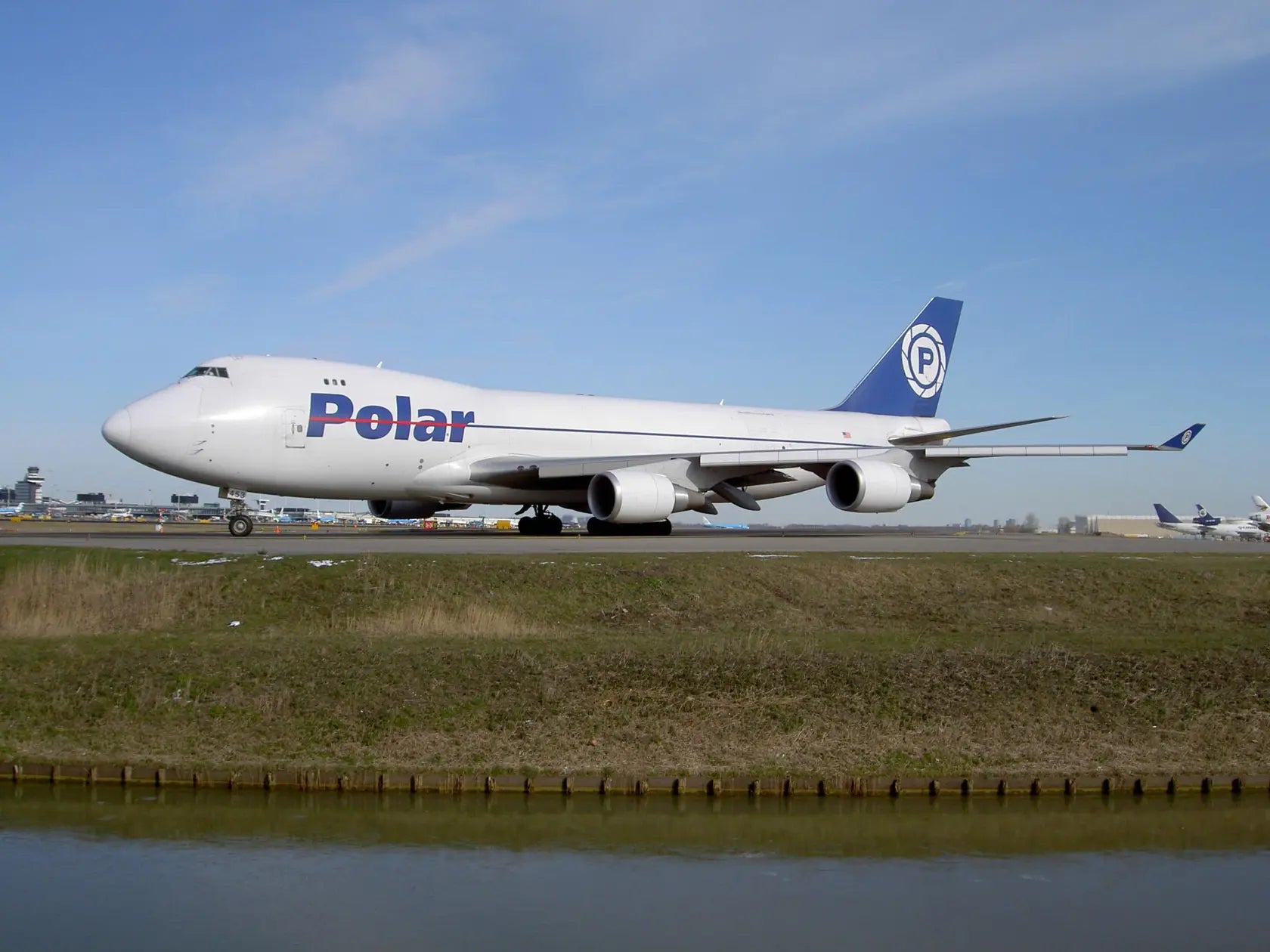 Boeing 747-46NF Polar Air Cargo aircraft on runway at Amsterdam Schiphol Airport, 28 February 2005, with clear sky and airport facilities in background.