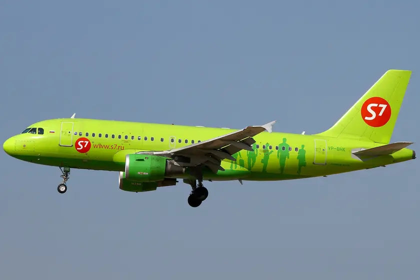Airbus A319-114 airplane in S7 Airlines livery in flight against a clear blue sky.