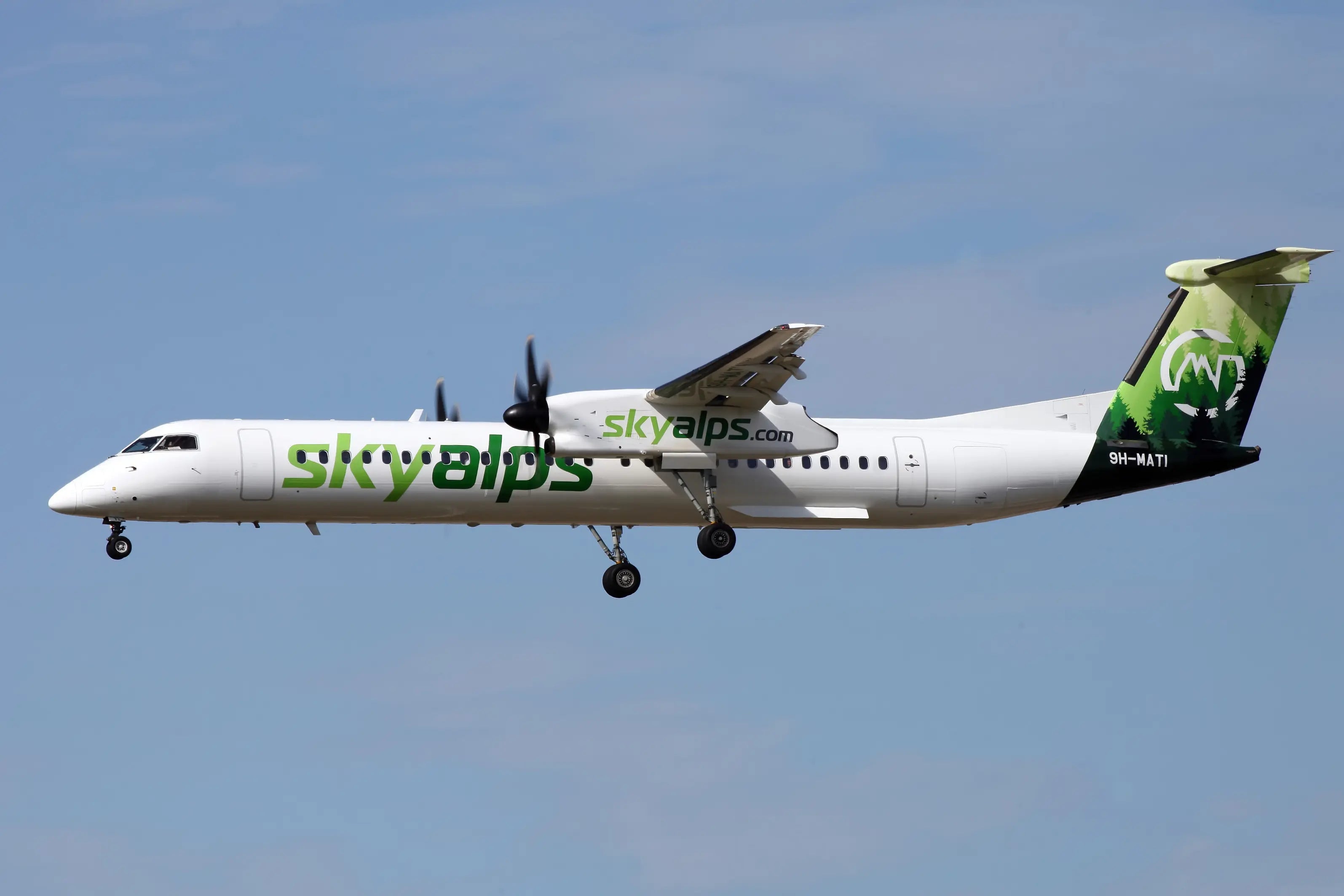 SkyAlps Bombardier DHC-8-402Q Dash 8 aircraft in flight with visible landing gear and green forest-themed tail, registration 9H-MATI.